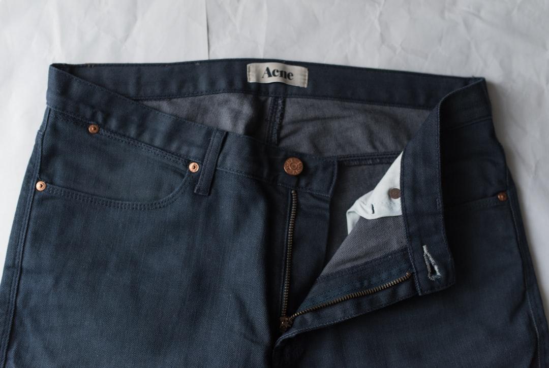 Folded dark denim jeans stacked neatly on a shelf
