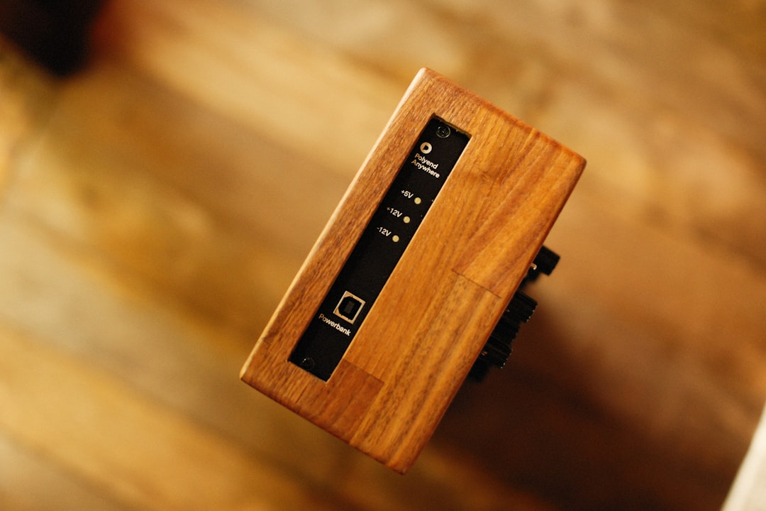 close up concealed cable organizer box behind wooden desk leg hiding power strip